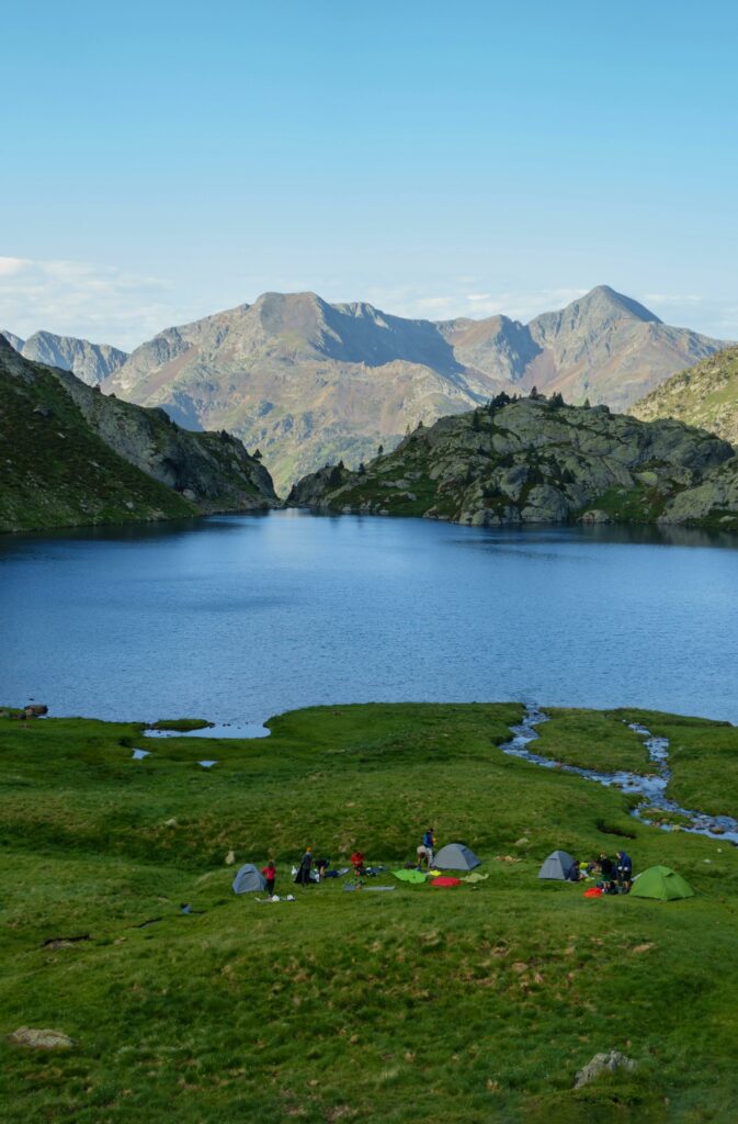 Explore a vibrant campsite by a picturesque mountain lake with stunning views in Spain.